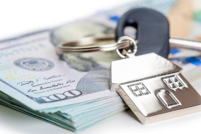 home-keys-sell-money House keys on a pile of US Dollars