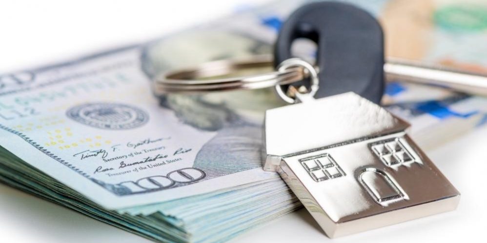home-keys-sell-money House keys on a pile of US Dollars